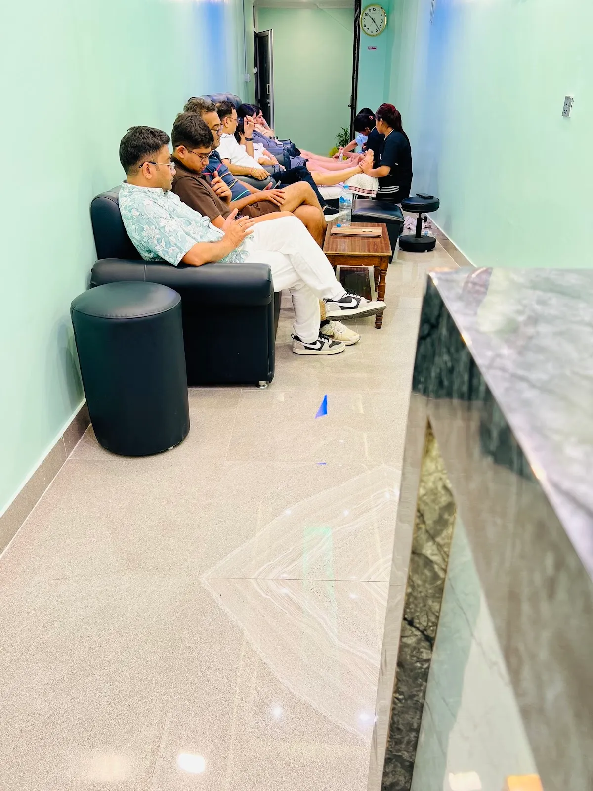 Guests resting in the lounge along the soft sage-painted hallway