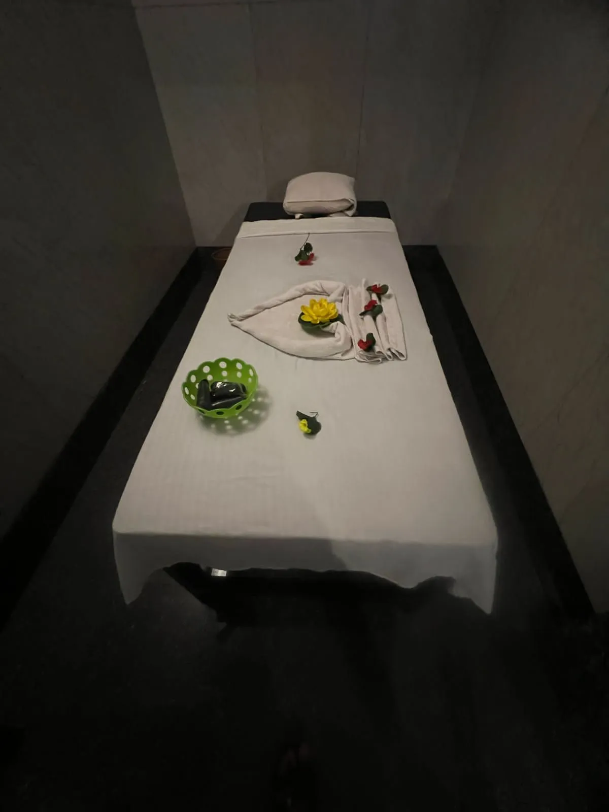 A single private treatment room ready for a guest, low-lit and quiet